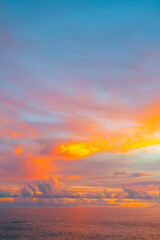 Serene sunset seascape with rich orange clouds and fading twilight light.