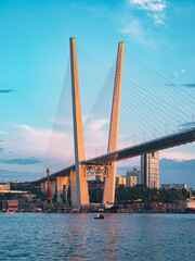 View of the Zolotoy Bridge in Vladivostok with Ships in the Harbor at Sunset