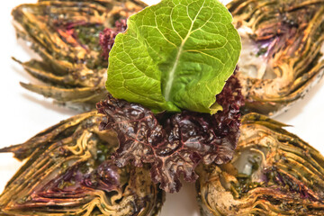 Grilled artichokes, grilled artichoke halves with sauces isolated on white background