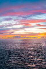 Twilight calm over sea with stunning orange clouds and sunset hues.