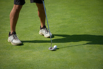 Close up of a golfer putting on a practice green