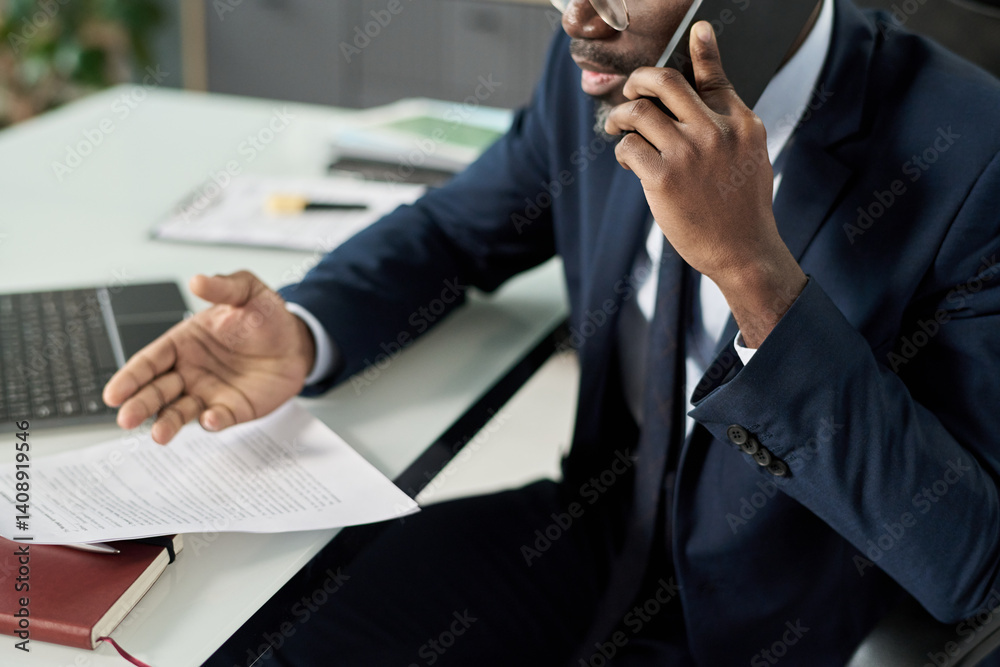 Poster businessman sitting at table in office and discussing contract on the phone with customer