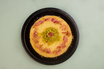 Kunafa is Arabic Traditional Desserts in a Plate With Pistachio and Roses Petal.