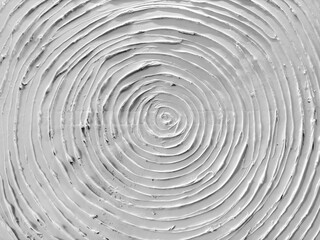Decorative 3d white textured paint on a wall or panel. In spiral circular shape, or round circle pattern. Rough uneven surfaces. Suitable for graphic background. Seamless background texture.