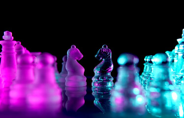 two glass chess knights facing each other