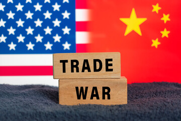 trade war word text on wooden blocks with america and china flag in the background. concept of geo politics conflict between two countries