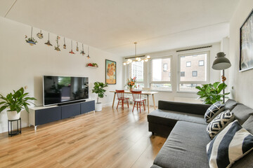 A stylish living room featuring sleek furniture, vibrant decor, and lush plants, creating a cozy and inviting atmosphere for relaxation and gatherings.