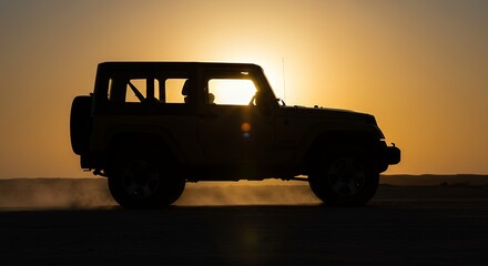 Driving Car in Silhouette at Sunset on Sandy Terrain