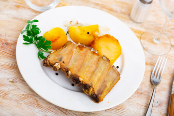 Stylishly served plate of tasty pork ribs with some potatoes