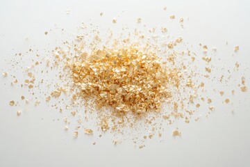 Shimmering gold glitter rests on a pristine white surface, creating a striking contrast.