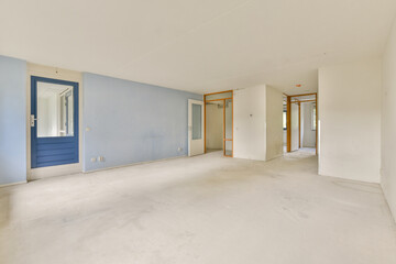 An empty room showcasing soft blue walls, a doorway, and light-colored flooring, creating a tranquil space ready for decoration or use.