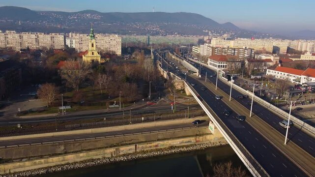 Aerial overview over Budapest highway and bridge during sunset with traffic and cityscape below