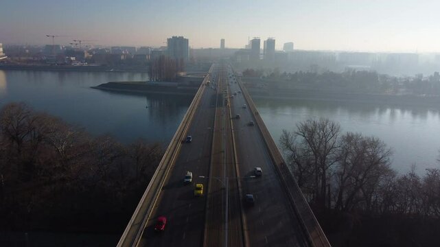 Drone flies above Budapest rail and bridge network with soft light on buildings and roads