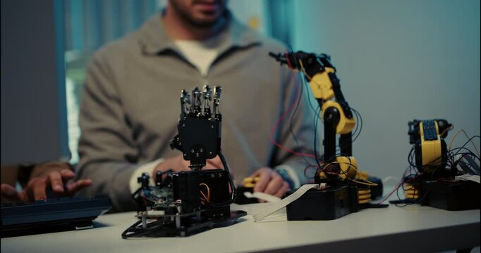 Close-up of engineers developing robotic arms and circuit boards in a modern technology lab. Hands-on robotics and innovation concept in action.