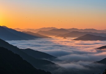 Fototapeta premium Sunrise over mountains with clouds in valleys and golden sky.