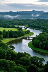 Obraz premium trees and grass surround a river in a valley with mountains in the background