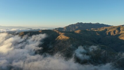 Drone Photo of Majestic Mountains at Sunset with Soft Clouds