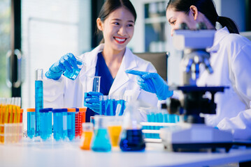 Two female biotechnologists testing new chemical substances in a laboratory.