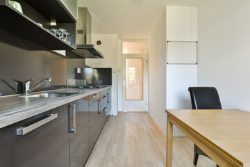 A sleek and contemporary kitchen featuring minimalist cabinetry, a well-organized layout, and functional space for cooking and dining. The design emphasizes clean lines and efficiency.