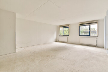 A spacious and empty room featuring large windows that invite natural light, creating a bright and airy atmosphere suitable for decoration and design.