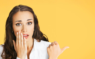 Image - expressive surprise, shock businesswoman hold hand near face, show free text space. Bunette...