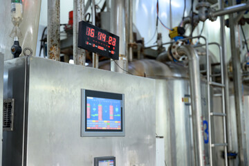 An industrial control panel with digital displays and monitoring screens in a modern manufacturing...