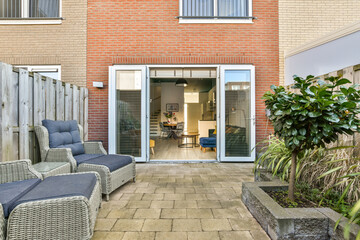 A contemporary patio showcases comfortable seating, modern architecture, and greenery, merging...