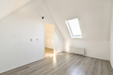 A spacious, modern interior featuring an angular design with ample natural light from a skylight....