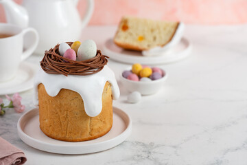 Traditional Easter cake decorated with a chocolate nest and candy eggs.  Homemade Orthodox dessert. Easter bread Kulich. Selective focus. Copy space