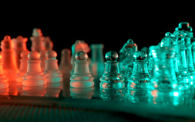 Transparent glass chess set illuminated by neon lights © Jeffrey