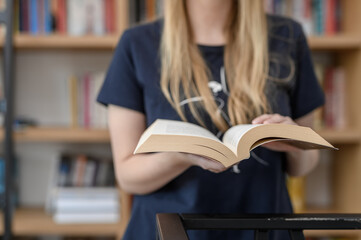 Kobieta przeglądająca książki w bibliotece, lektury szkolne i czytanie książek, wiedzą i nauka 