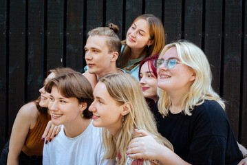 Group of smiling teenagers looking up with joy outdoors
