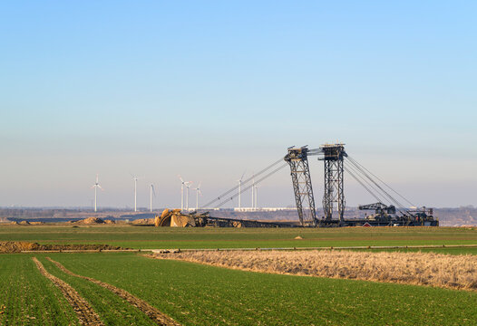 Lignite mining site near Garzweiler with excavator and wind turbines in the background