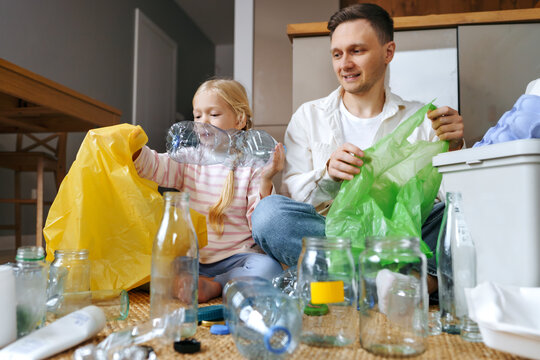 Father and daughter sorting waste at home focusing on sustainability and recycling