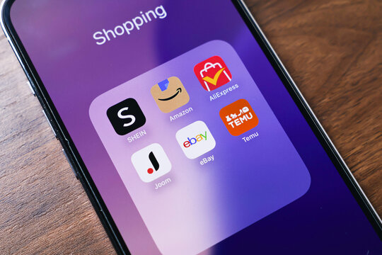 Poznan, Poland - March 26, 2025: Smartphone folder named Shopping with SHEIN, Amazon, AliExpress, Temu, eBay, and Joom apps