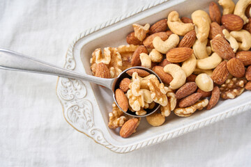 白い器に盛り付けたミックスナッツとスプーン