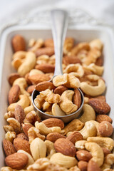 白い器に盛り付けたミックスナッツとスプーン