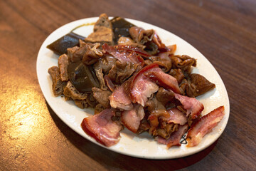 Close-up of Taiwanese braised dish with pork, tofu, and intestines, highlighting traditional cooking techniques and bold, rich flavors