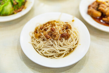 Taiwanese braised noodle with minced pork, rich soy sauce flavor, served on a white plate, showcasing local comfort food tradition