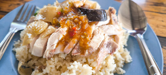 Chicken rice in a blue plate on a wooden table