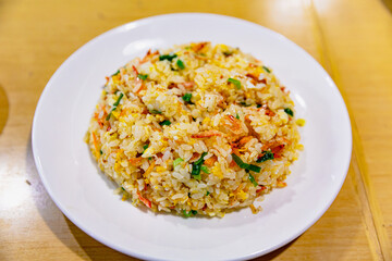 Taiwanese-style egg fried rice with sakura shrimp served in a white plate, golden grains glistening with oil and umami flavor