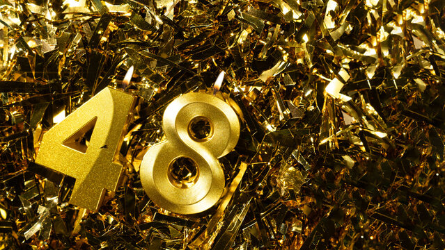 Number 48 golden candle for celebration birthday on festive tinsel background. Forty-eighth year birthday. Concept of celebrating birthday and anniversary.