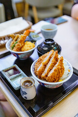 Japanese pork cutlet and tempura combo bowl shot with shallow depth of field, featuring crispy katsu and shrimp over steamed rice