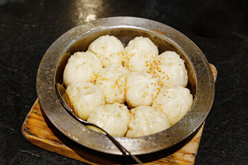Shanghai sheng jian bao with crispy golden pan-fried base, fluffy top, and juicy pork filling,...