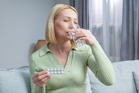 Blonde woman in her 50s taking hormone replacement pills