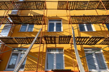 Building facade renovation, scaffolding. Extensive scaffolding providing platforms for work during renovation in a multi-story building