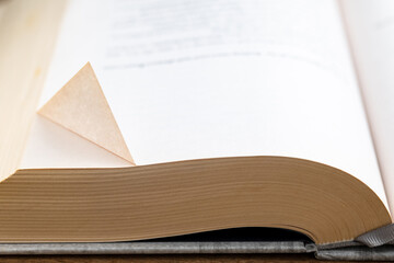 The folded corner of a page of a book indicates the interesting message on that page, bookmark, dog...