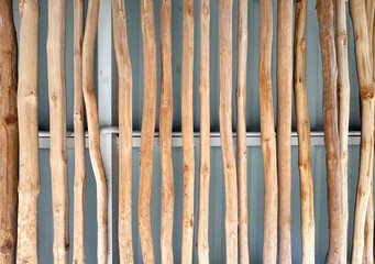 Series of natural dried wooden stick trunks from an oak tree. Wooden branch or trunk coated and varnished, installed parallel on ceiling as natural ethnic design.
