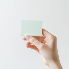 Obraz premium Hand Holding Blank Card: Create Personalized Business Card Mockups for Office Presentation and Social Media Branding