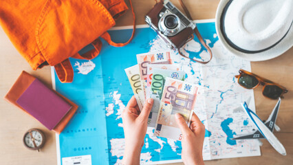 Woman holding money on travel background